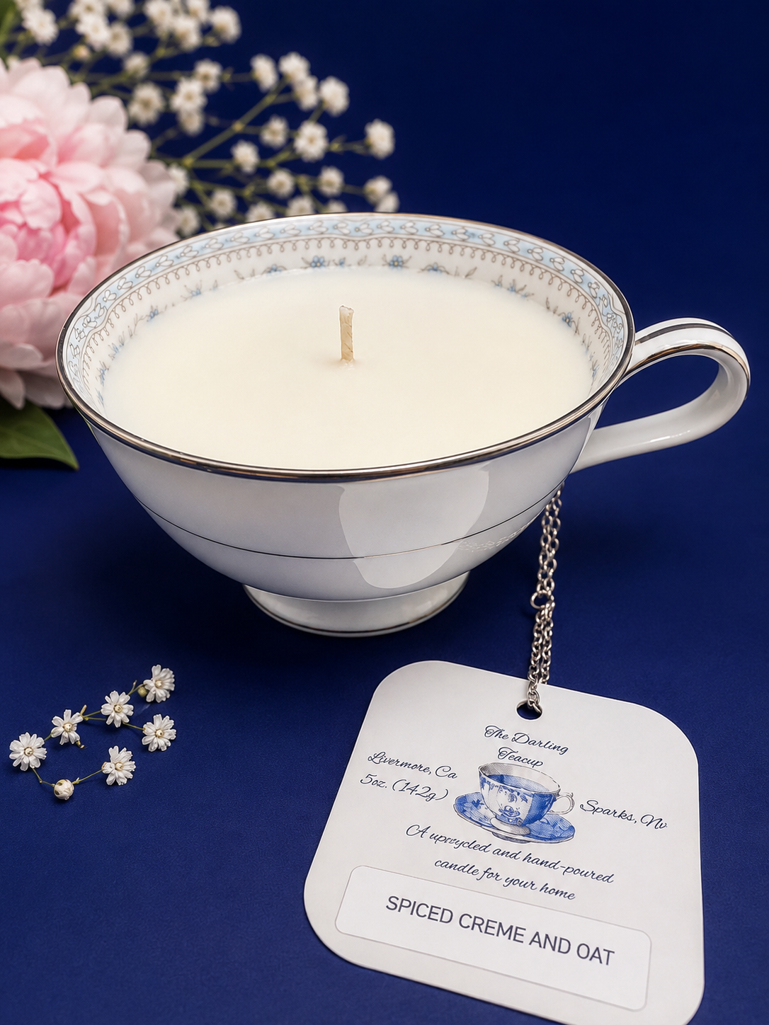 Vintage teacup candle, Noritake china in collection Colburn. White cup, silver trim, blue and silver intricate floral trim on the inside of cup. Scented with Spiced Creme & Oat. 